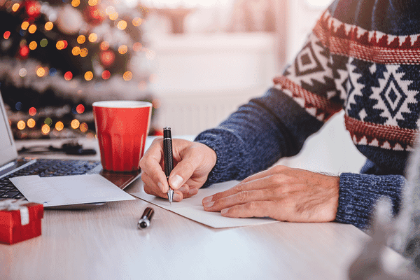 Holiday gifts grouping of tumbler, notebook, pen, and plaid blanket