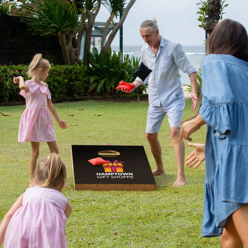 family playing bean bag toss game during small business saturday event