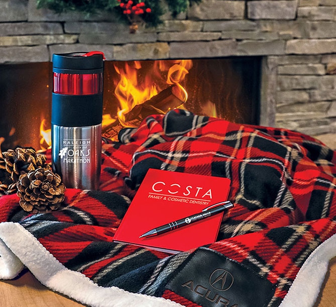 Holiday gifts grouping of tumbler, notebook, pen, and plaid blanket