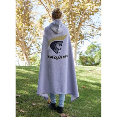 Woman standing in green grass wearing a grey hooded sweatshirt blanket with a large logo