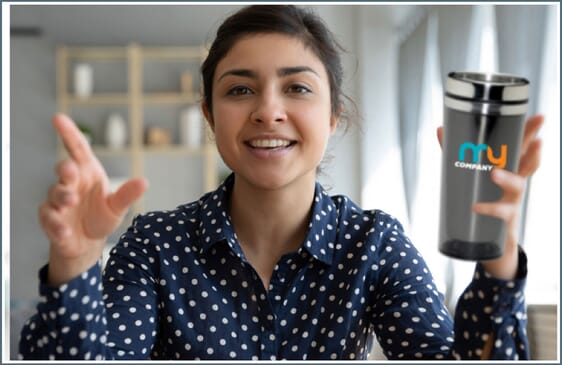 Woman holding up travel mug with company logo