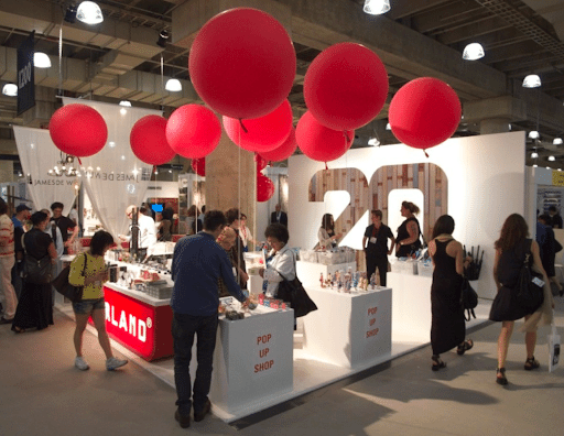 Pop-up shop booth for the brand Kikkerland decorated with large red balloons