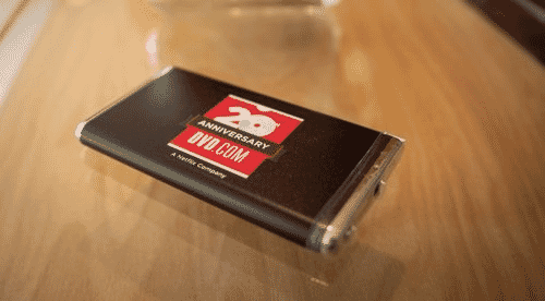 Black, red and silver Netflix-branded power bank on brown wooden table