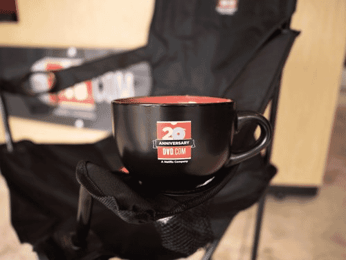 Red and black Netflix-branded mug sitting on the arm of a black camping chair