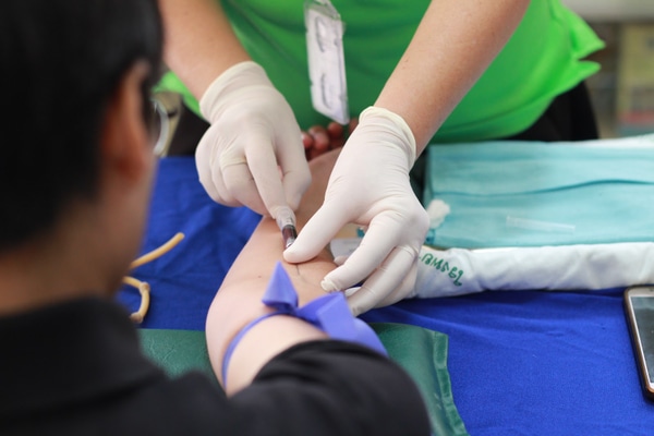 Nurse drawing blood from a patient's arm