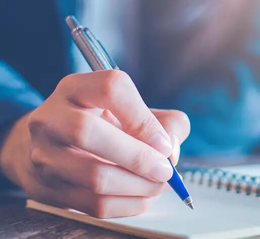 Writing with pen in notebook