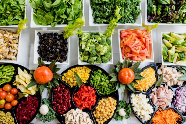 Bowls and trays of chopped vegetables laid out on a table