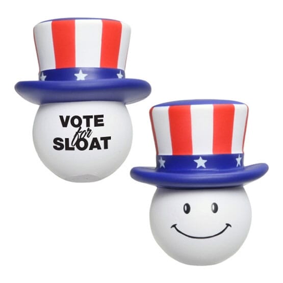 White smiley face stress ball with red, white and blue USA-themed hat and a black logo.