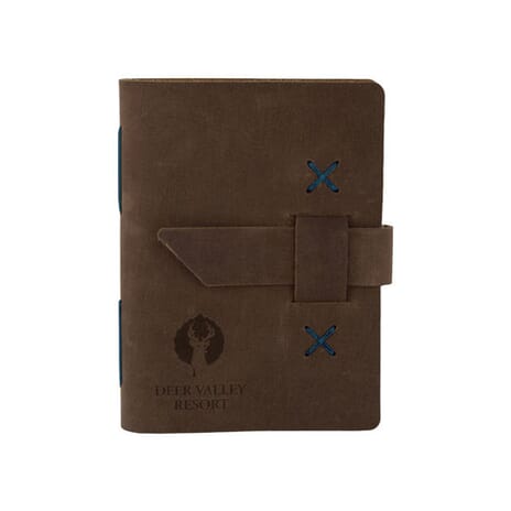 Dark brown leather journal with debossed logo and strap closure